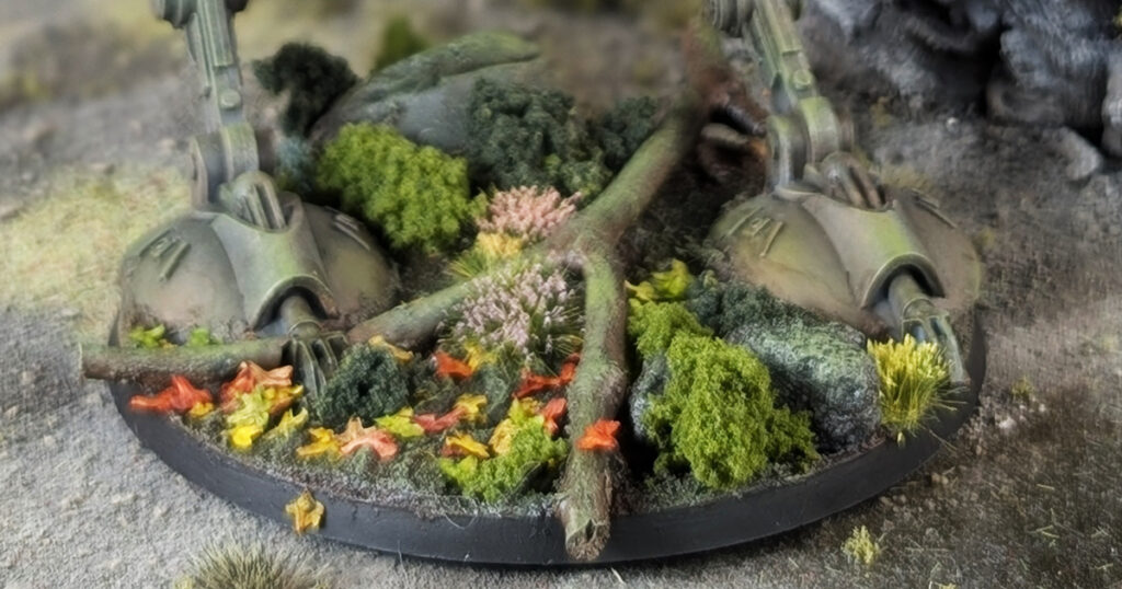 Miniature painting base with an Endor forest theme featuring dark soil texture, realistic green moss, and miniature ferns.